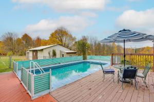 a deck with an umbrella and chairs and a pool at Pet-Friendly Ohio Escape with Pool, Deck and Fire Pit! in Mount Vernon