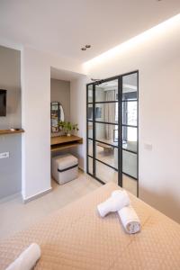 een slaapkamer met een bed met twee handdoeken erop bij Athens Genesis Luxury Suites in Athene