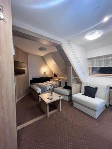 コパオニクにあるApartment Maja Konaciのベッド3台とテーブルが備わるホテルルームです。