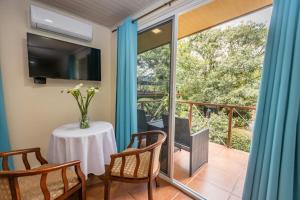 Zimmer mit einem Tisch und Stühlen sowie einem Balkon in der Unterkunft El Oasis Hotel y Restaurante in Boquete