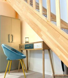 a desk with a blue chair next to a staircase at LOASIS - Duplex T4 Hypercentre in Villefranche-sur-Saône