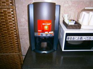 un modello di macchina da caffè accanto a un forno a microonde di APA Hotel Miyazaki Miyakonojo Ekimae a Miyakonojō