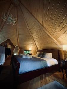 a bed in a room with a wooden ceiling at Aos Sí Lodges in Ballachulish