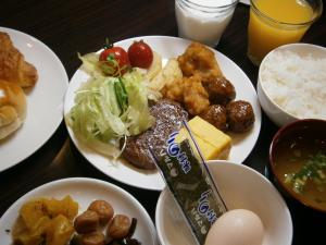 une table avec des assiettes de nourriture sur une table dans l'établissement APA Hotel Miyazaki Miyakonojo Ekimae, à Miyakonojō