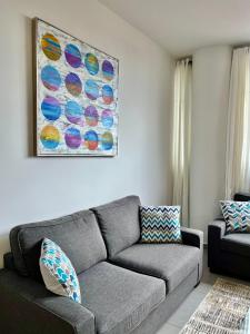 a living room with a couch and a painting on the wall at Signature Point Bella Vista, Sea View 2 BR in Panama City