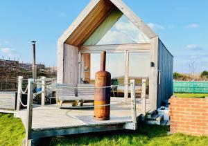 a small house with a pipe on a deck at Lushna 11 Lux Suite at Lee Wick Farm Cottages & Glamping in Clacton-on-Sea