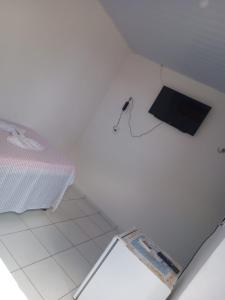 a white room with a bed and a box on the floor at Pousada da Rotatória in São Gonçalo do Amarante