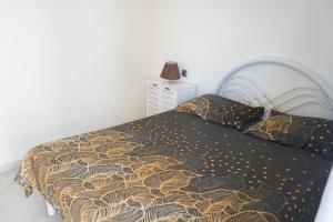 a bed with a black and gold blanket and pillows at Charming 2 bdr apt, Palmarejo Grande, Praia - LCGR in Praia