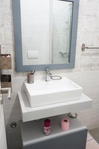 a bathroom with a white sink and a mirror at Charming 2 bdr apt, Palmarejo Grande, Praia - LCGR in Praia