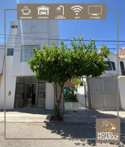 un edificio con un albero di fronte di HOTEL HUARAZ a Tacna