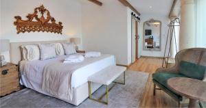 um quarto com uma cama grande e uma cadeira em Hotel Real d Obidos em Óbidos