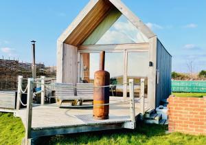 a small house with a pipe on a deck at Lushna 12 Lux at Lee Wick Farm Cottages & Glamping in Clacton-on-Sea