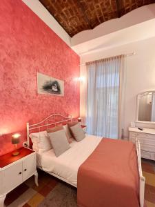 - une chambre avec un lit et un mur rouge dans l'établissement Suite Scarlatti, à Naples