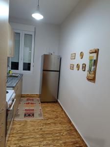 een keuken met een koelkast en een houten vloer bij flora's memories appartment in Kavala