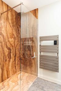 a bathroom with a shower with a wooden wall at L'Ardoise, L'Anjou, La Vigne et La Loire in Angers