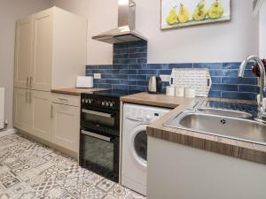 a kitchen with a sink and a dishwasher at Fairways in Prestatyn