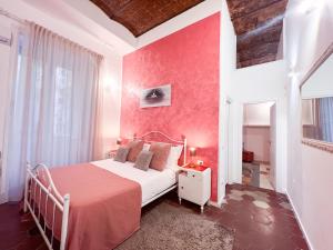 a bedroom with a bed and a red wall at Suite Scarlatti in Naples