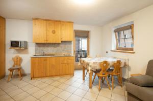 una cucina con un tavolo e sedie in una stanza di Baita Francisi a Livigno