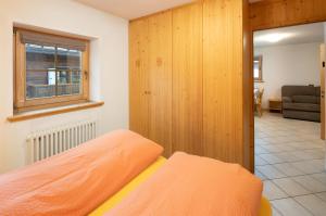 una camera da letto con un letto con una parete in legno di Baita Francisi a Livigno