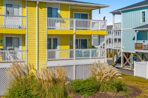 a row of houses with yellow and white balconies at Captain's Villa 9-C Sunshine Ally in Holden Beach