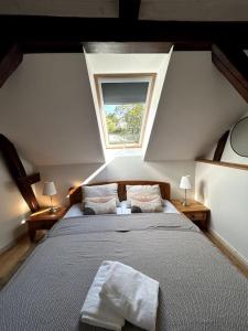 a attic bedroom with a bed with a window at Loft in Historischer Schmiede in Berlin
