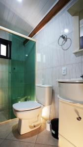 ein Badezimmer mit Toilette und Glasdusche in der Unterkunft Residencial Beija Flor Apartamento 23 in Bombinhas + 20 Fotos