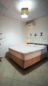 ein Schlafzimmer mit einem großen Bett in einem Zimmer in der Unterkunft Residencial Beija Flor Apartamento 23 in Bombinhas