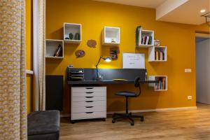 a desk in a room with a yellow wall at Casetta al centro in Trento