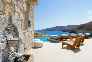 a patio with a fireplace and a view of the water at Anassa Boutique Hotel in Livadi Astypalaias