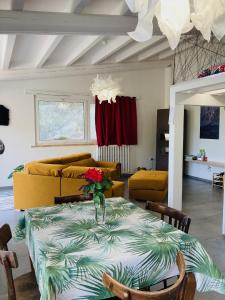 a living room with a table with a vase of flowers on it at La casetta sulle nuvole. in Cammarata