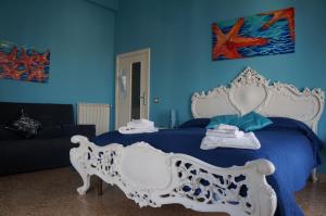 a blue bedroom with a white bed and a blue wall at QuiSiSana a mare in Castellammare di Stabia