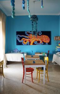 a dining room with a table and chairs with a painting at QuiSiSana a mare in Castellammare di Stabia