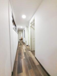un pasillo vacío con paredes blancas y suelo de madera en Medellin apartamento en laureles, en Medellín