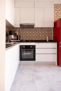 a kitchen with white cabinets and a black oven at 3 bdr cozy apt in Condominio Mi, Palmarejo Grande in Praia