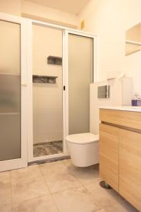 a bathroom with a toilet and a glass shower at 3 bdr cozy apt in Condominio Mi, Palmarejo Grande in Praia