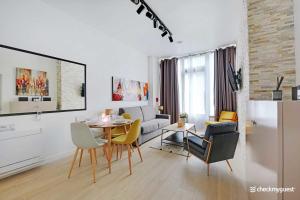 uma sala de estar branca com uma mesa e cadeiras em Cosy apartment RDC - Sacrée Coeur Montmartre em Paris