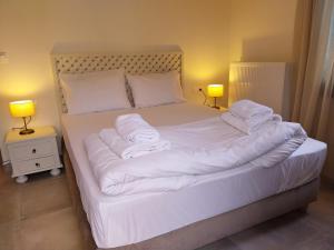 1 dormitorio con 1 cama con sábanas y almohadas blancas en Marousos Central Guesthouse en Portariá