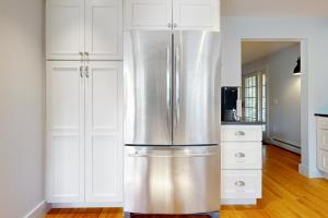un frigorifero in acciaio inossidabile in una cucina con mobili bianchi di Valley Serenity Retreat a Ludlow