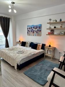 a bedroom with a large bed and a couch at Q Apartament Palas Mall in Iaşi