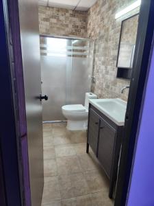 a bathroom with a toilet and a sink and a shower at Casa Las Minas en Pilón in Colón