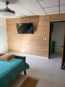 a bedroom with a flat screen tv on a wall at Casa Las Minas en Pilón in Colón