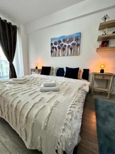 a bedroom with a large bed with two towels on it at Q Apartament Palas Mall in Iaşi