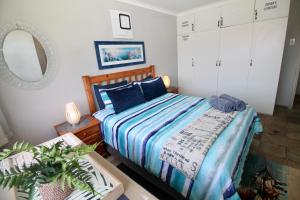 a bedroom with a bed and a mirror and a table at Du Bantry 14 in Uvongo Beach