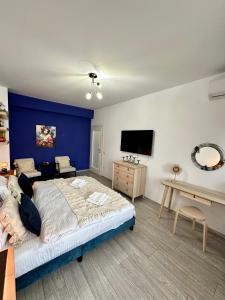 - une chambre avec un grand lit et un mur bleu dans l'établissement Q Apartament Palas Mall, à Iaşi