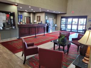 a lobby with a waiting area with chairs and a table at Victory Suites in Warren