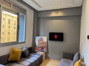 uma sala de estar com um sofá e uma televisão em Private apartment, bright and quiet em Tânger