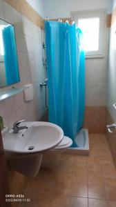 bagno con tenda doccia blu e lavandino di Acquario a Lido Marini