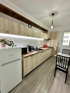 uma cozinha com armários de madeira e um frigorífico branco em Q Apartament Palas Mall em Iaşi