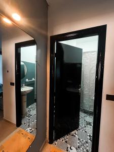 uma casa de banho com uma porta preta e um espelho em Private apartment, bright and quiet em Tânger