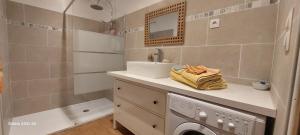 a bathroom with a sink and a washing machine at Gîte le Fort in Vesseaux